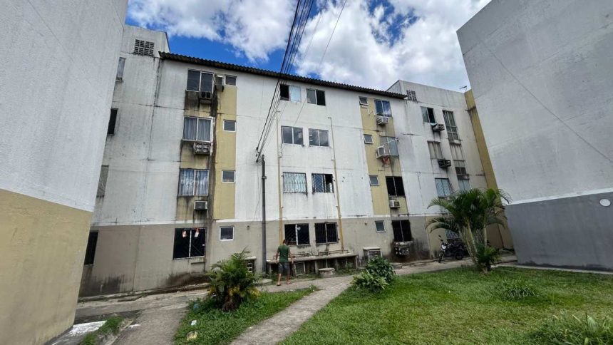 Prédio residencial no programa Viver Melhor, com sinais de falta d'água e possível multa.
