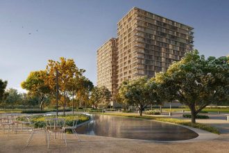 Prédios modernos em meio a área verde com árvores e espelho d'água, Ara Mirá e Volvo.