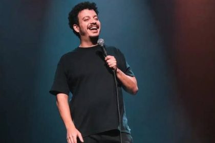 Rodrigo Marques sorrindo com microfone em show de stand-up