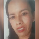 Rosto de mulher sorrindo com aparelho nos dentes, em fundo desfocado.