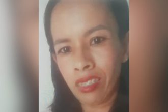 Rosto de mulher sorrindo com aparelho nos dentes, em fundo desfocado.