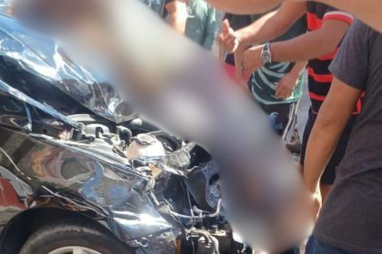 Veículo danificado em acidente de trânsito, com pessoas ao redor.