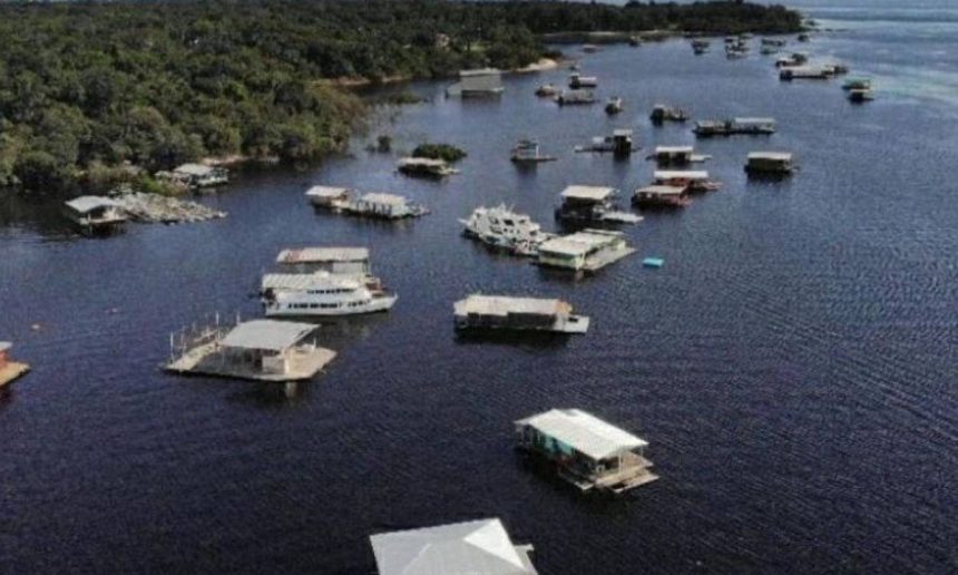 Vista aérea de flutuantes no rio Amazonas, com vegetação ao fundo.