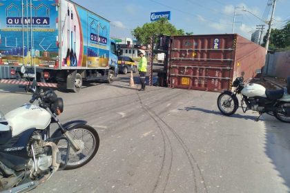 Acidente em Manaus: carreta tombada interdita avenida Autaz Mirim, com motocicletas e um caminhão ao fundo.