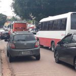 Agente de trânsito fiscalizando veículos em rua de Manaus com tráfego intenso.