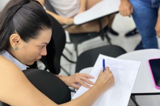 Aluna escrevendo em caderno durante curso de tráfego pago em Manaus.
