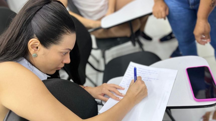 Aluna escrevendo em caderno durante curso de tráfego pago em Manaus.