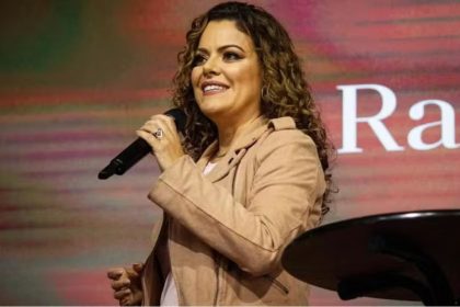 Ana Paula Valadão cantando com microfone em evento gospel.