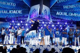 Anúncio do tema do Caprichoso para o Festival de Parintins 2026 com palco azul e figuras.