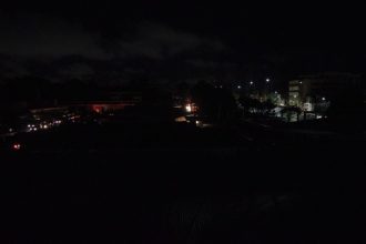 Apagão noturno em Manaus, Itacoatiara ou Parintins, com pouca iluminação e prédios ao fundo.