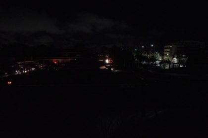 Apagão noturno em Manaus, Itacoatiara ou Parintins, com pouca iluminação e prédios ao fundo.