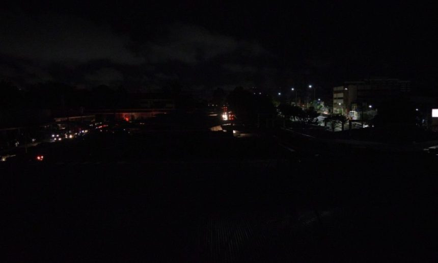 Apagão noturno em Manaus, Itacoatiara ou Parintins, com pouca iluminação e prédios ao fundo.