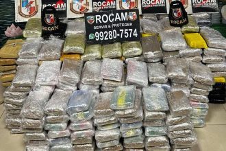 Apreensão de drogas pela polícia, com pacotes embalados e logotipos da ROCAM visíveis.