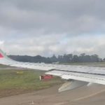 Asa de avião em aeroporto com neblina intensa.