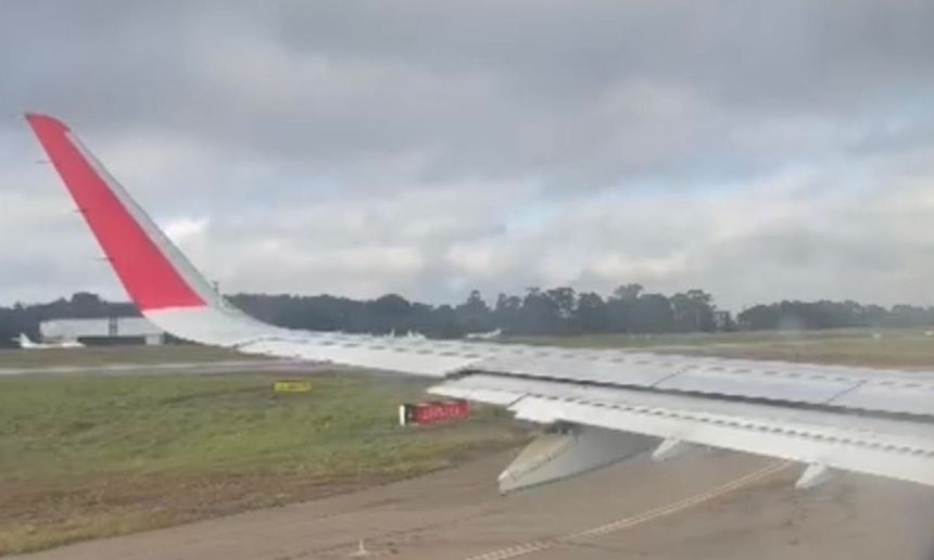 Asa de avião em aeroporto com neblina intensa.