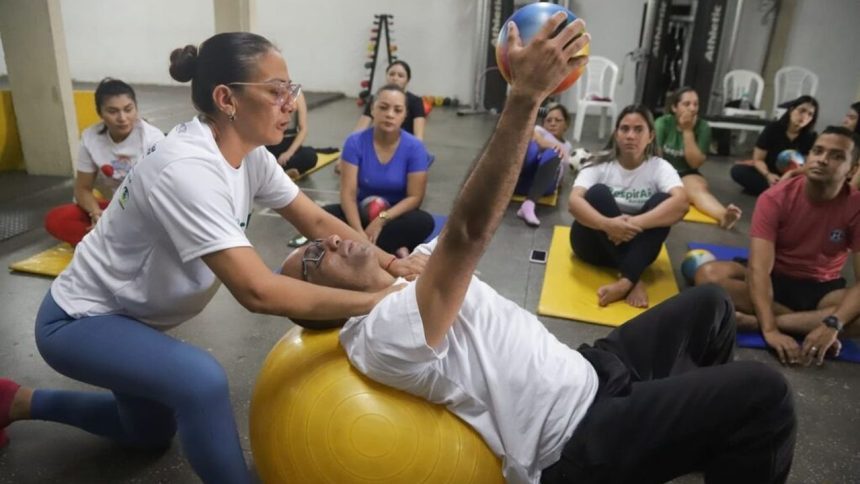 Aula de pilates com instrutora auxiliando um aluno em exercício.