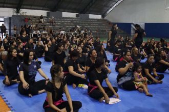 Aulão solidário de defesa pessoal feminina em Ponta Negra, com mulheres reunidas em um ginásio.