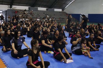Aulão solidário de defesa pessoal feminina em Ponta Negra, com mulheres reunidas em um ginásio.