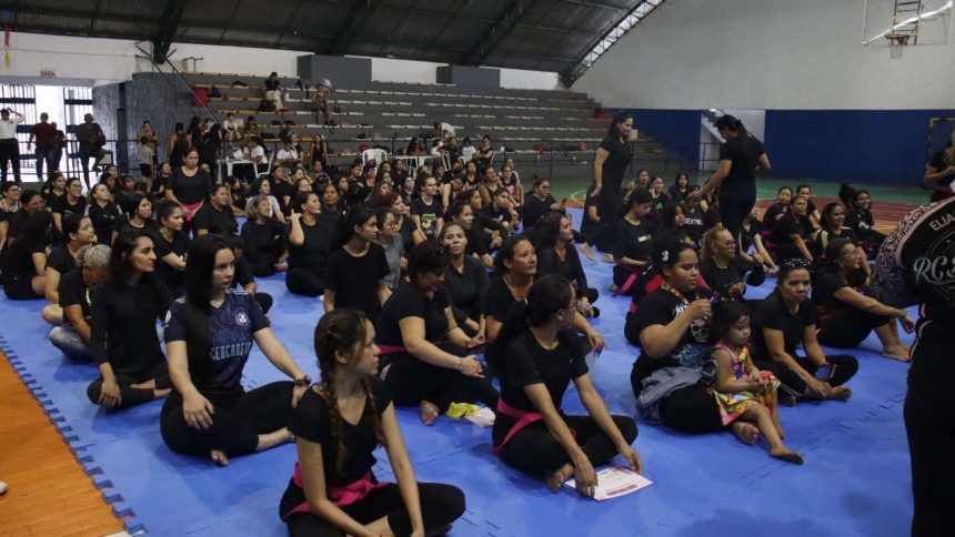 Aulão solidário de defesa pessoal feminina em Ponta Negra, com mulheres reunidas em um ginásio.