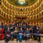 Banda Amazonas em palco, com músicos e instrumentos, posando para foto