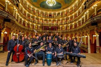 Banda Amazonas em palco, com músicos e instrumentos, posando para foto