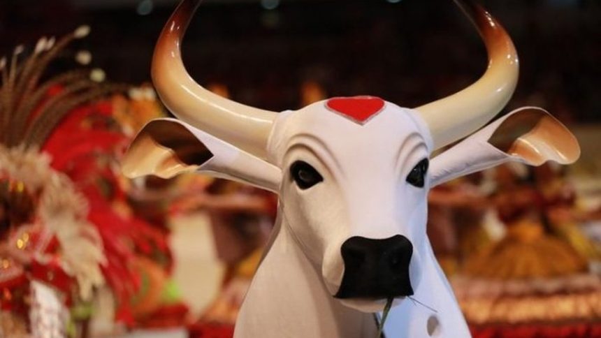 Boi Garantido, com chifres e coração vermelho, em evento. Detalhe de rosto.