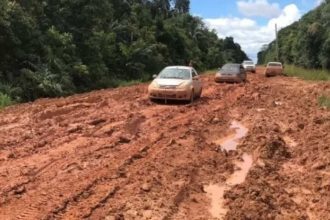 BR-319: Carros atolados em estrada de terra lamacenta, reflexo de problemas com licenças ambientais.