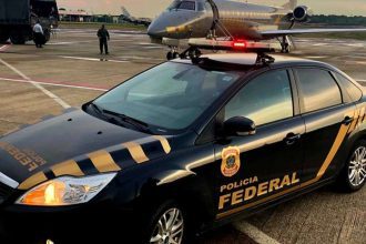 Carro da Polícia Federal em ação no aeroporto com avião ao fundo