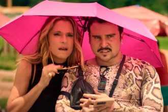 Casal sob guarda-chuva rosa em evento do 'Perrengue Fashion'.