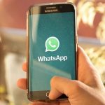 Celular Samsung com tela do WhatsApp em destaque, em mãos.