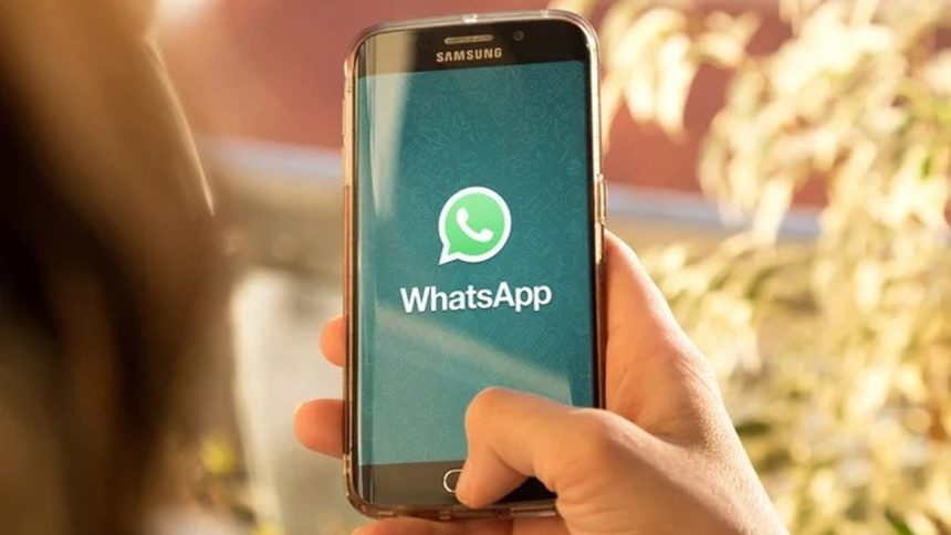 Celular Samsung com tela do WhatsApp em destaque, em mãos.