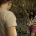 Cena de "A Bota de Lama" com duas crianças em um ambiente natural.