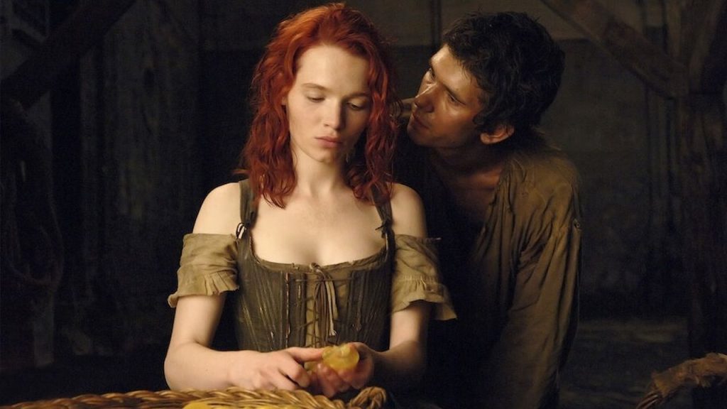Cena romântica de filme em um casarão antigo, com um casal em trajes de época.