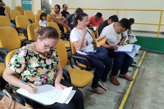 Convocados preenchem formulários em treinamento para campanha contra raiva animal em Manaus.