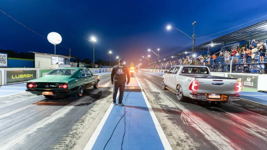 Corrida de arrancada em Iranduba, com carros e público na arquibancada.