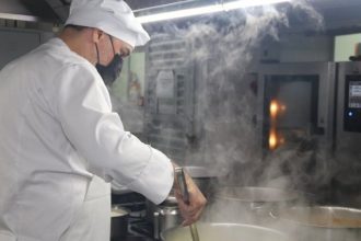 Cozinheiro do Sesc Amazonas em Manaus preparando alimentos na cozinha.