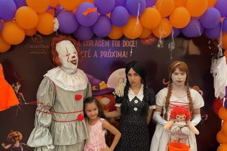 Crianças e adultos fantasiados de personagens de terror em evento de Halloween.