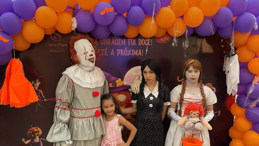 Crianças e adultos fantasiados de personagens de terror em evento de Halloween.
