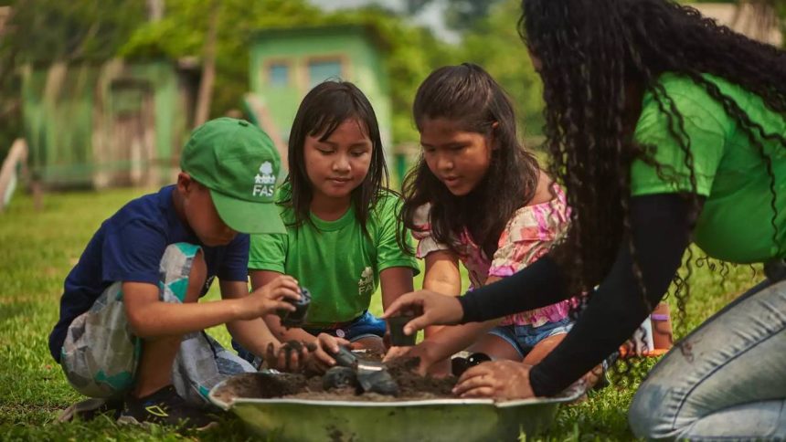 Crianças e consultora da FAS plantando em atividades educacionais no Amazonas.