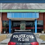 Delegacia de Polícia Civil com carro da polícia em frente.