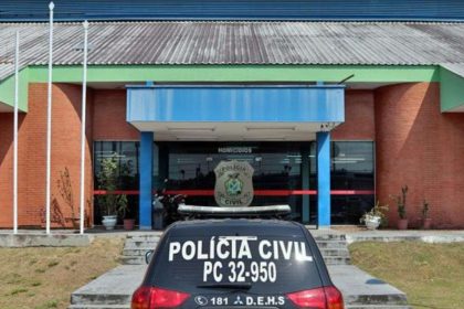 Delegacia de Polícia Civil com carro da polícia em frente.