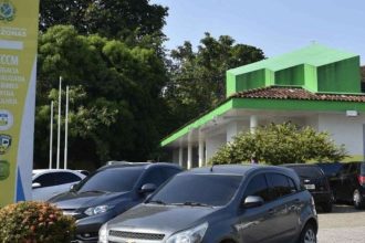 Delegacia Especializada em Crimes Contra a Mulher em Manaus, com carros estacionados.