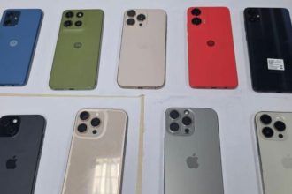 Diversos iPhones e celulares Motorola expostos em mesa, possivelmente roubados.