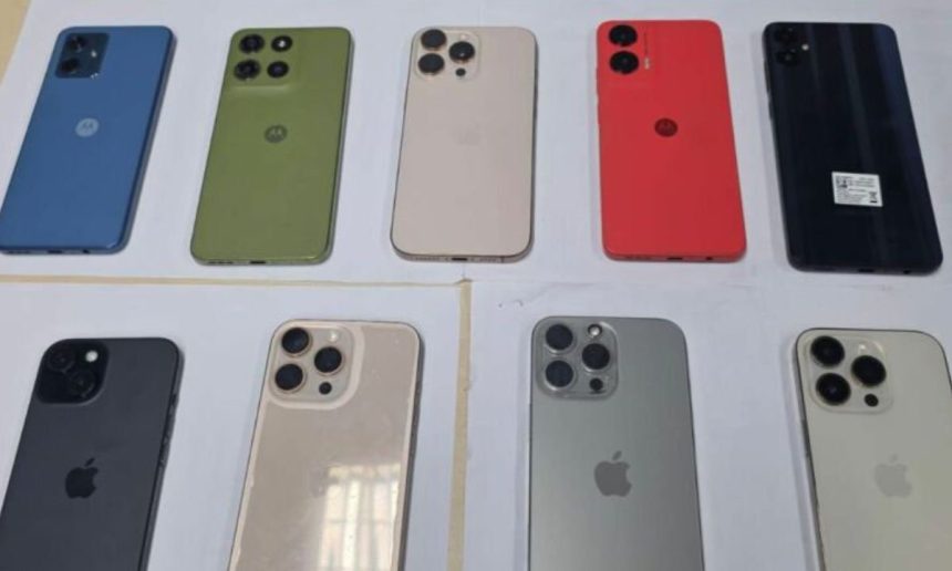 Diversos iPhones e celulares Motorola expostos em mesa, possivelmente roubados.
