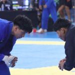 Dois atletas de jiu-jítsu se preparam para uma luta em uma competição.