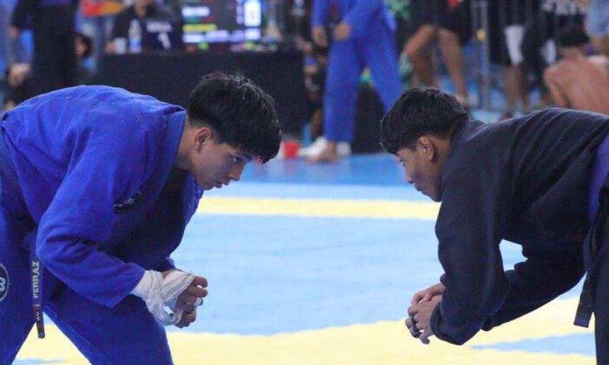 Dois atletas de jiu-jítsu se preparam para uma luta em uma competição.