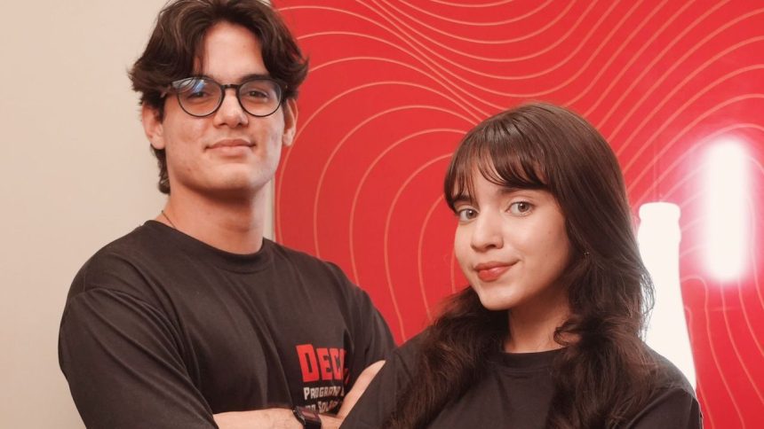 Dois jovens sorrindo em frente a um fundo vermelho com linhas curvas.