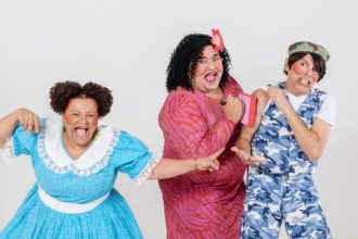 Elenco de 'Dona Batata' em apresentação teatral, com figurinos coloridos e expressões exageradas.