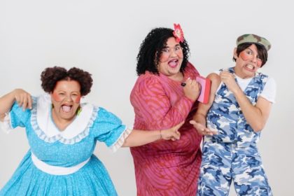 Elenco de 'Dona Batata' em apresentação teatral, com figurinos coloridos e expressões exageradas.