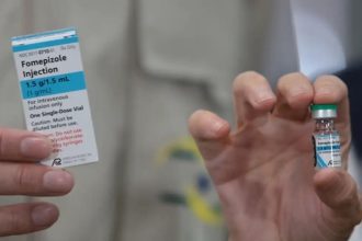 Embalagem de Fomepizole Injection, antídoto contra intoxicação por metanol, sendo segurada pela mão de uma pessoa.
